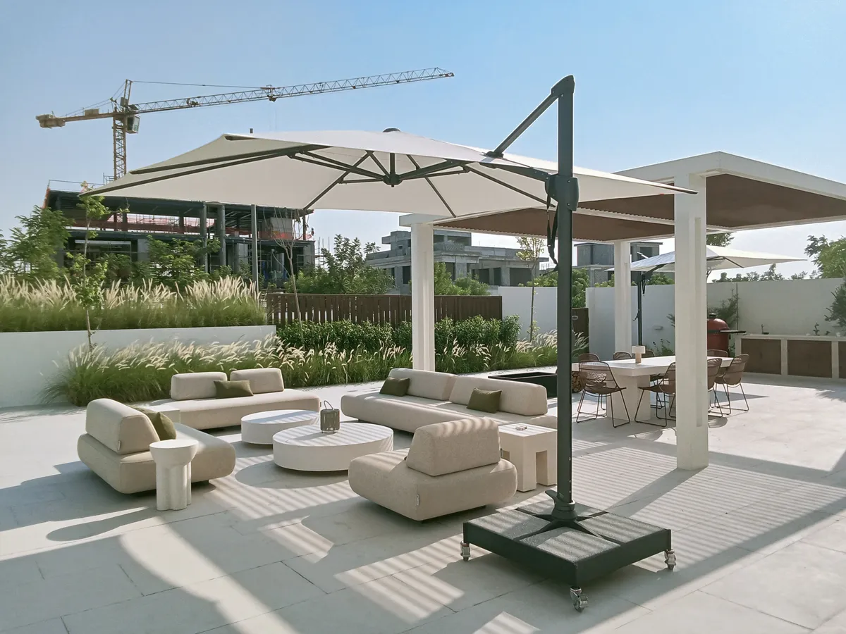 Fortano cantilever umbrella on wheeled base beside lounge seating in Jubail Island